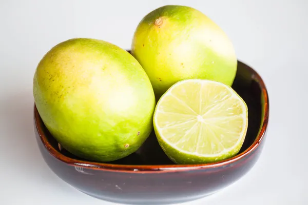 Fresh limes whole and slice in ceramic bowl — Stock Photo, Image