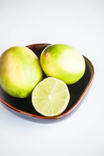 Fresh citrus limes whole and slice in ceramic bowl — Stock Photo, Image