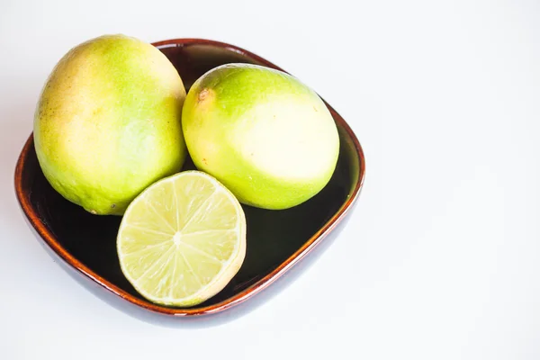 Fresh citrus limes whole and slice in bowl on white background — Stock Photo, Image