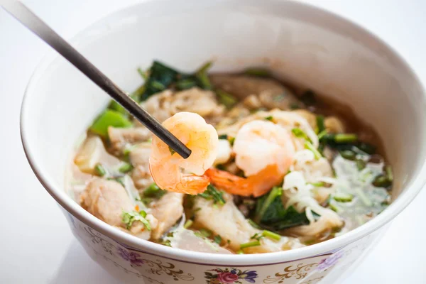 Main tenir les crevettes avec des baguettes de style thaï nouilles épicées sou — Photo