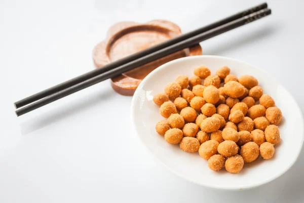 Snack de cacahuetes recubierto con condimentos picantes y palillos —  Fotos de Stock