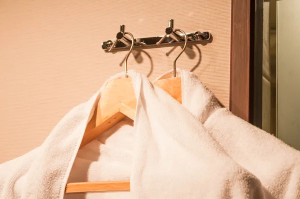 Witte handdoeken op houten hanger met warm licht — Stockfoto