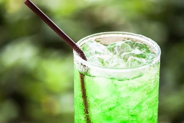 Glass of iced green drink with straw — Stock Photo, Image