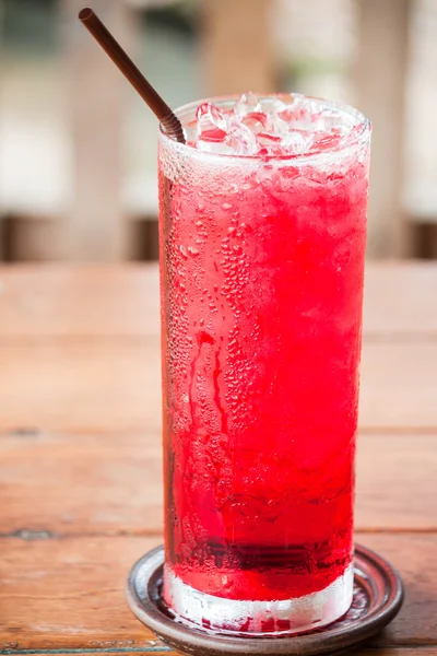 Glass of cold red drink with straw — Stock Photo, Image