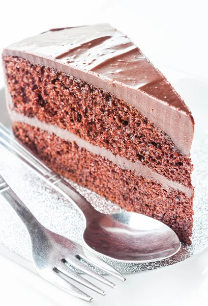 Cerrar pedazo de pastel de chocolate con cuchara y tenedor — Foto de Stock