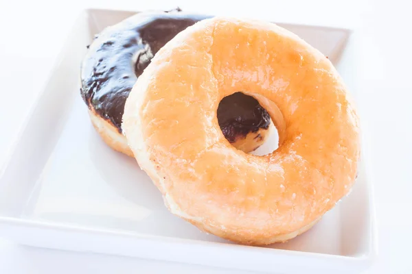 Classic and chocolate donuts on white plate — Stock Photo, Image