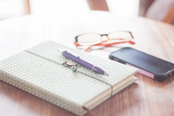 Notebook en smartphone op houten tafel — Stockfoto