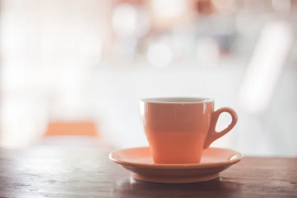 Copo de café laranja na mesa de madeira — Fotografia de Stock