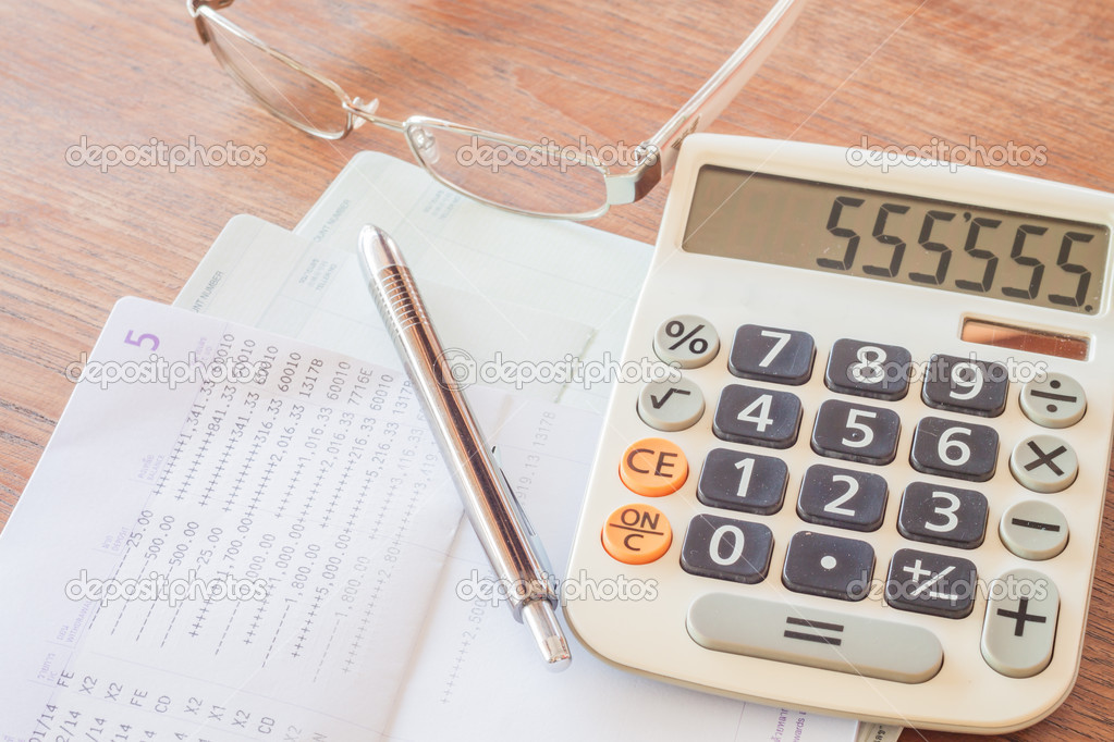 Calculator, pen and eyeglasses on bank account passbook