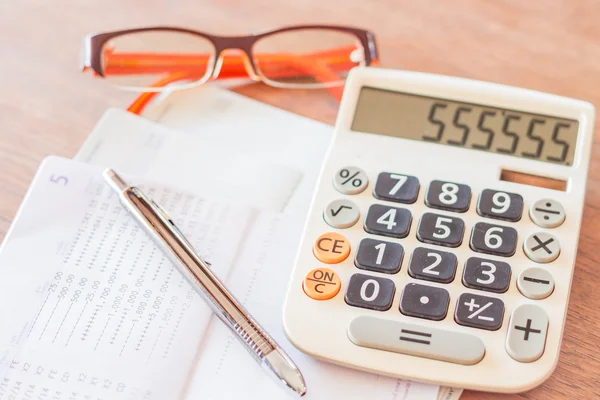 Work station with calculator, pen and eyeglasses — Stock Photo, Image
