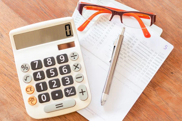 Vista superior da calculadora, caneta, óculos e passboo conta bancária — Fotografia de Stock
