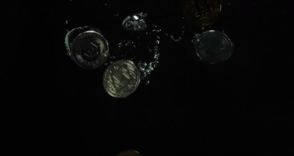 Lassú mozgás: A bitcoin fémérméi a vízbe esnek, gyönyörű kiemelésekkel, fekete háttérrel. A koncepció a csökkenő cryptocurrency árfolyam. Elektronikus pénzügyi tranzakciók — Stock videók
