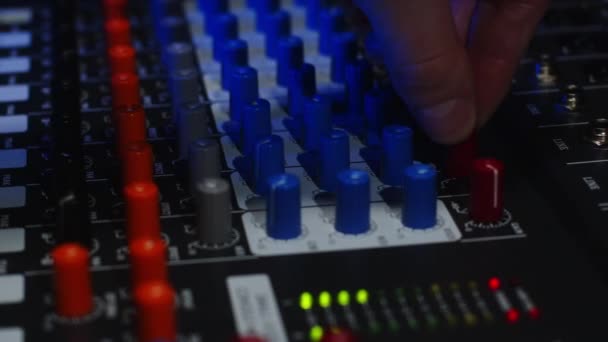 Ingénieur du son augmente le volume de musique lors d'une fête à l'aide d'un mélangeur sonore multi-canaux professionnel. Macro shot — Video