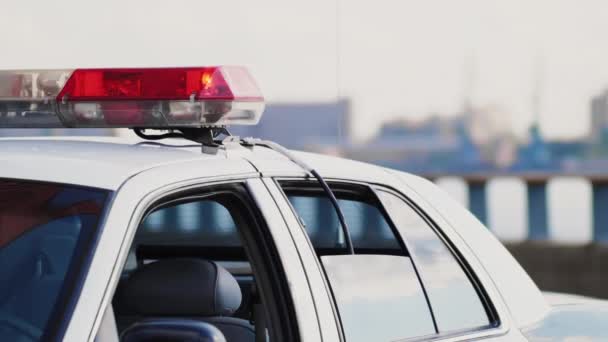 Polis teşhircisi şehir merkezinin arka planında arabada. — Stok video
