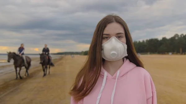 Maskeli kız sahilde izole edilmiş. Salgın sırasında yalnızlık. Yüksek kalite 4k görüntü