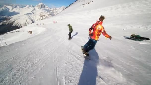 Snowboarder muestra habilidades de esquí en las montañas. Snowboarder feliz en la pista — Vídeos de Stock