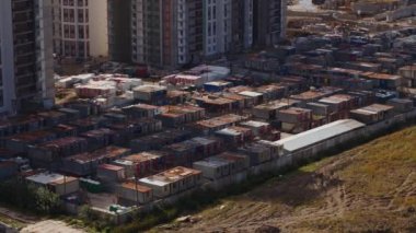 İşçiler için berbat bir yaşam koşulları. Gökdelenlerin yanındaki gecekondular. İş kasabası