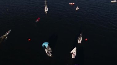 Yelkenli gemiler yelkenli yarışlarının bitiş çizgisini geçip İHA 'nın etrafında dönüyorlar.
