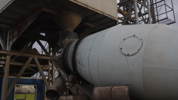 Vuile betonmixer laadt beton in de achterkant van een betonfabriek - close-up — Stockvideo