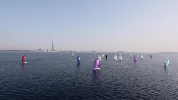 Sailing yachts lined up in the sea during a sailing regatta and cast shadows — Stock Video