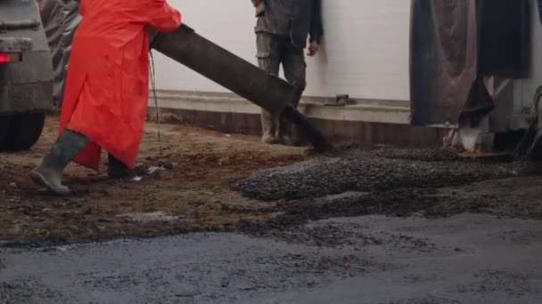 Рабочий заливает бетон на строительной площадке. Разгрузка бетона - крупным планом — стоковое видео