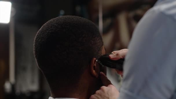 The trimmer cuts the curled hair of an African American - macro shot — Stock Video