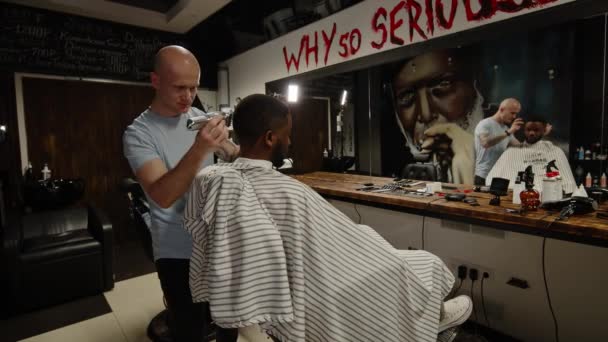 Parrucchiere bianco facendo acconciatura a bello giovane uomo africano americano — Video Stock