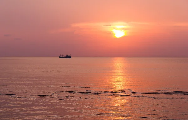 Vissersboot bij zonsondergang in de zee — Stockfoto