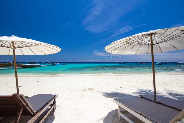 White umbrella and chairs on white beach — Stock Photo, Image