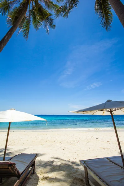 Weiße Sonnenschirme und Liegestühle am weißen Strand — Stockfoto