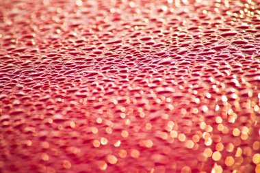 Kırmızı yüzeyde su damlaları