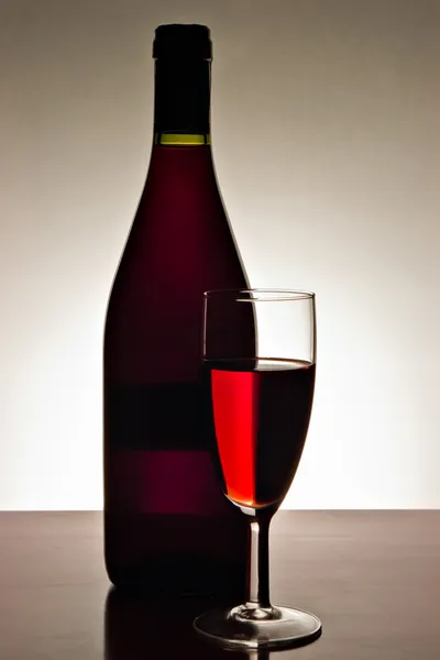 Copo de vinho tinto e garrafa — Fotografia de Stock