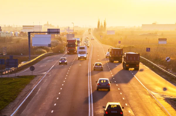 Auto's en vrachtwagens bij zonsopgang — Stockfoto