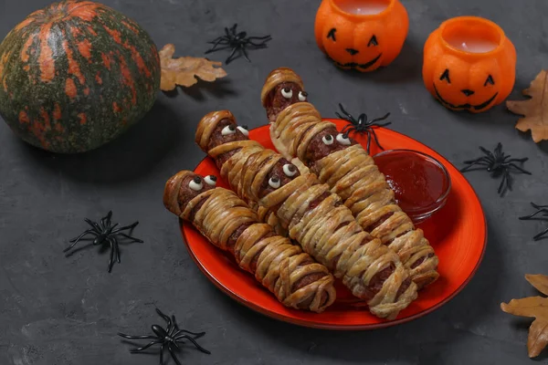 Straszne mumie kiełbasek w cieście z ketchupem na Halloween party serwowane na ciemnym stole — Zdjęcie stockowe