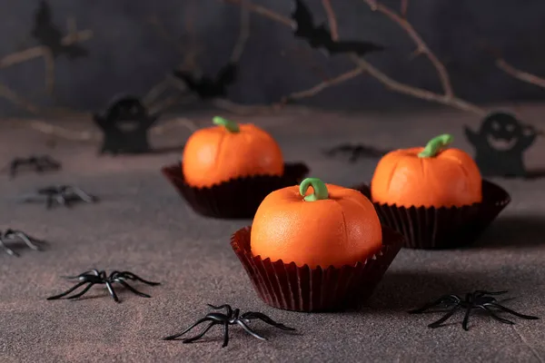 Deser na Halloween - słodkie ciasto musowe w kształcie dyni na ciemnym tle z wystrojem pająków i nietoperzy — Zdjęcie stockowe