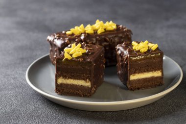 Mangolu çikolatalı bademli browni ve tutkulu meyve reçeli gri arka planda çikolata jöleli.