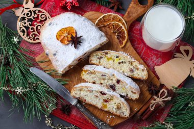 Kuru meyve ve bir bardak sütle dilimlenmiş Noel aromalı stollen. Geleneksel Alman ziyafetleri. Üst görünüm