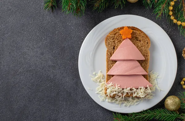 Sandwich amuzant cu pomul comestibil de Crăciun făcut din pâine prăjită, cârnați, morcov și brânză. Idei de mic dejun pentru copii. Privire de sus cu spațiu de copiere. Anul Nou fundal . fotografii de stoc fără drepturi de autor