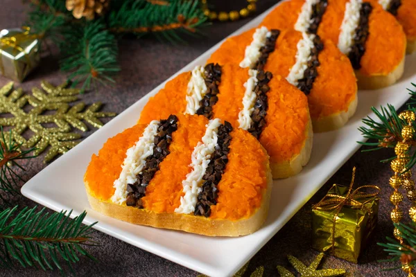 Sandvișuri de tigru pentru Anul Nou 2022 de morcov, ouă și măsline negre pe pâine albă pe fundal maro Imagine de stoc