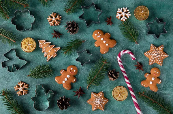 Homemade christmas gingerbread cookies, candles, walking stick and cookie cutters on green new year background, Flat lay, Top view — Stock Photo, Image