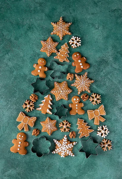Pomul de Crăciun din prăjituri de turtă dulce și matrițe pentru turtă dulce pe fundal verde, Vizualizare de sus Imagini stoc fără drepturi de autor