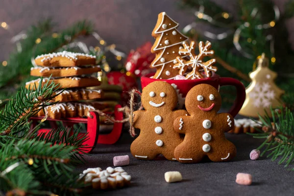 Efsanevi zencefilli kurabiye adamlar, kar taneleri ve noel ağacı şeklinde. Yeni yıl dekorasyonu için kırmızı kızaklar ve köknar ağacı dalları