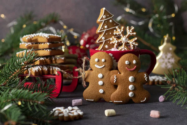 Biscuiți de turtă dulce sub formă de bărbați fabuloși de turtă dulce, fulgi de zăpadă și copac de Crăciun. Sani rosii si ramuri de brad pentru decorarea compozitiei noului an fotografii de stoc fără drepturi de autor