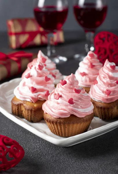 Homemade cupcakes decorated with cream and heart-shaped sprinkles for Valentines Day on gray background — Zdjęcie stockowe