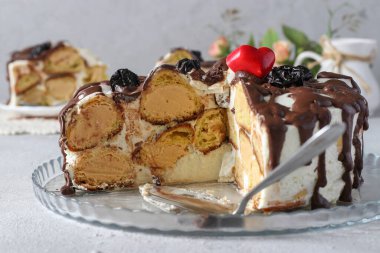 Profiterol Keki, porsiyonlara bölünmüş, yakın plan, arka planda kek parçası.