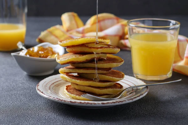 Fritter-urile de lapte sunt turnate cu sirop dulce și servite la micul dejun cu suc de portocale — Fotografie, imagine de stoc
