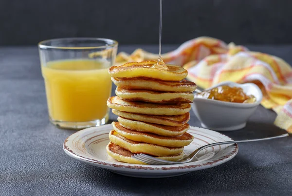 Los buñuelos de leche se vierten con jarabe dulce y se sirven para el desayuno con zumo de naranja. — Foto de Stock