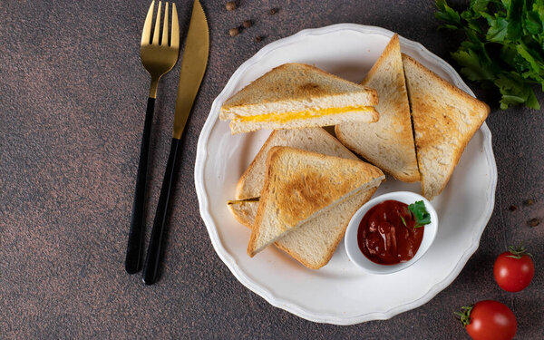 Sandwiches with egg and cheese fried in pan served with tomato sauce for breakfast