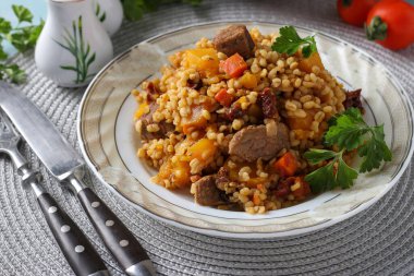 Balkabağı, havuç, soğan ve güneşte kurutulmuş domates gibi bulgur ve sebzeli sığır eti.