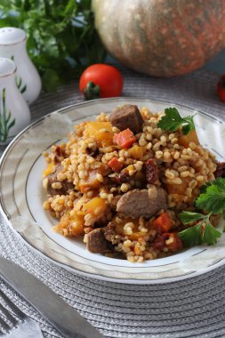 Balkabağı, havuç, soğan ve güneşte kurutulmuş domates, dikey format gibi bulgur ve sebzeli biftek.